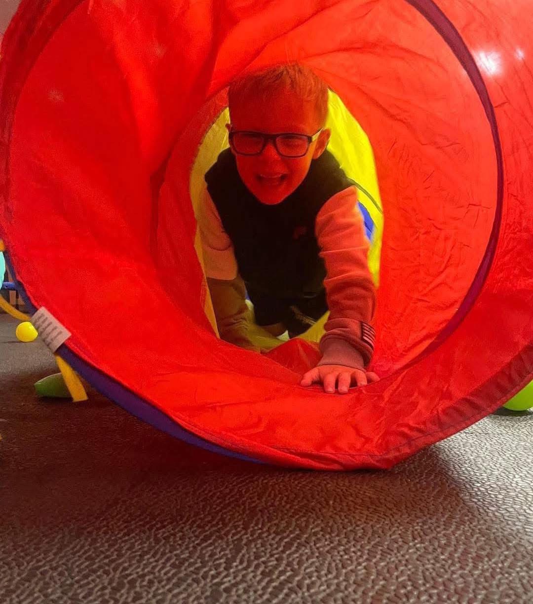 Young person having fun in a tunnel at The Trin Centre
