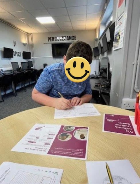A young person writing in a workbook